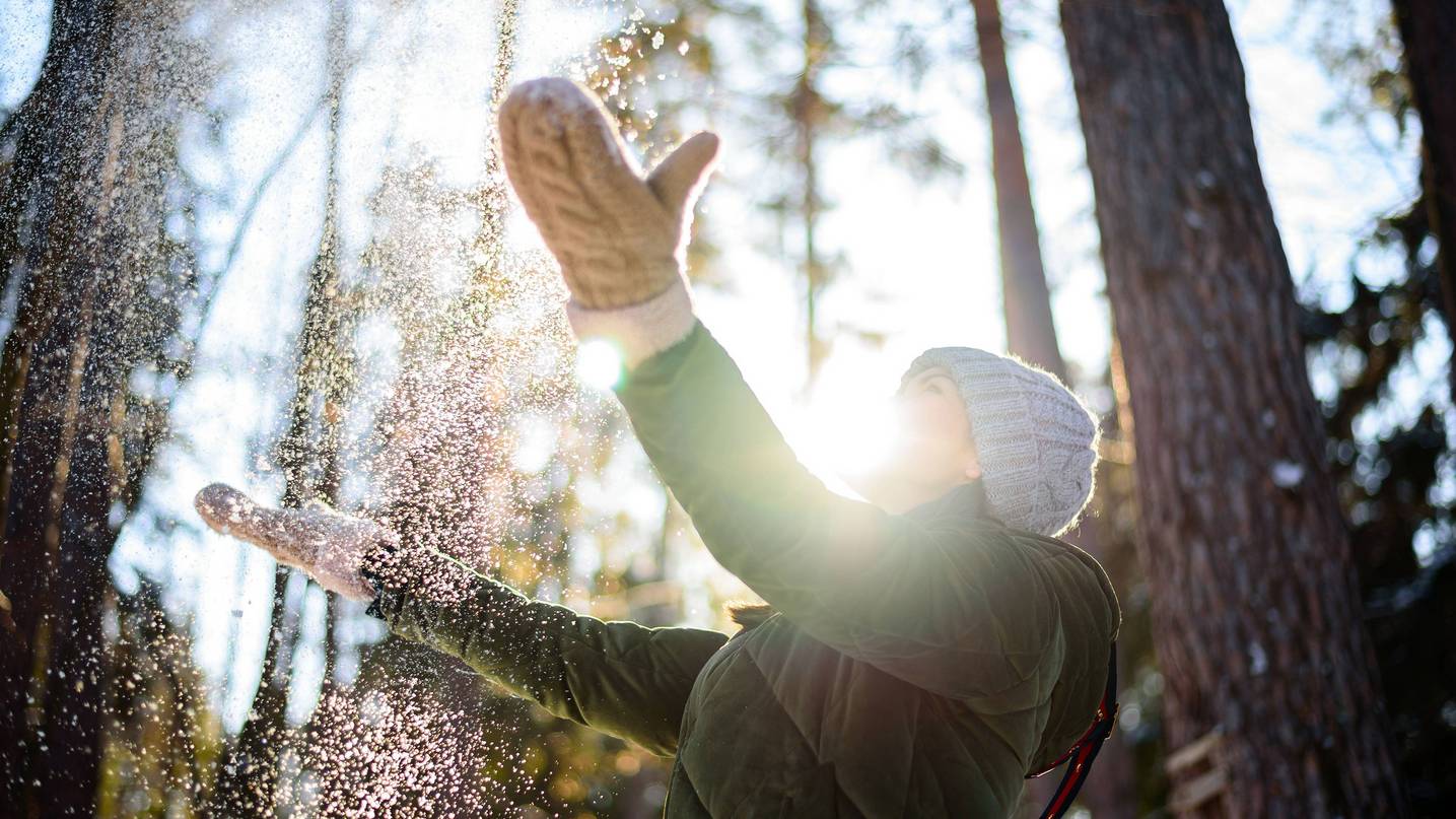 Frau im Winterwald und die Sonne scheint